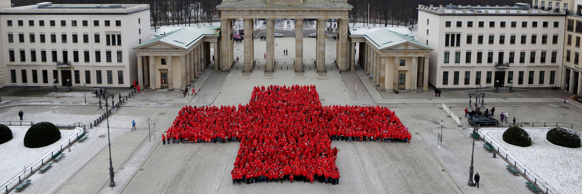 Hunderte DRK-Mitarbeiter formen ein Rotes Kreuz am Brandenburger Tor