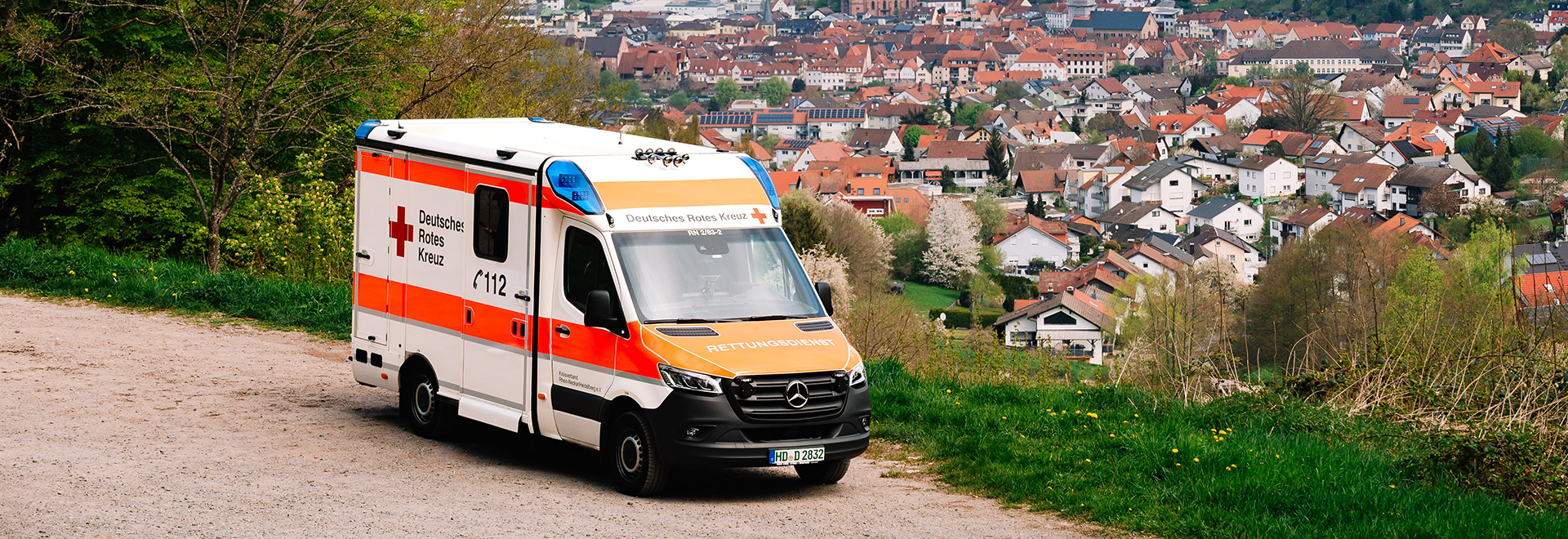 Ein Krankenwagen steht neben einem Abhang mit Blick auf die Stadt