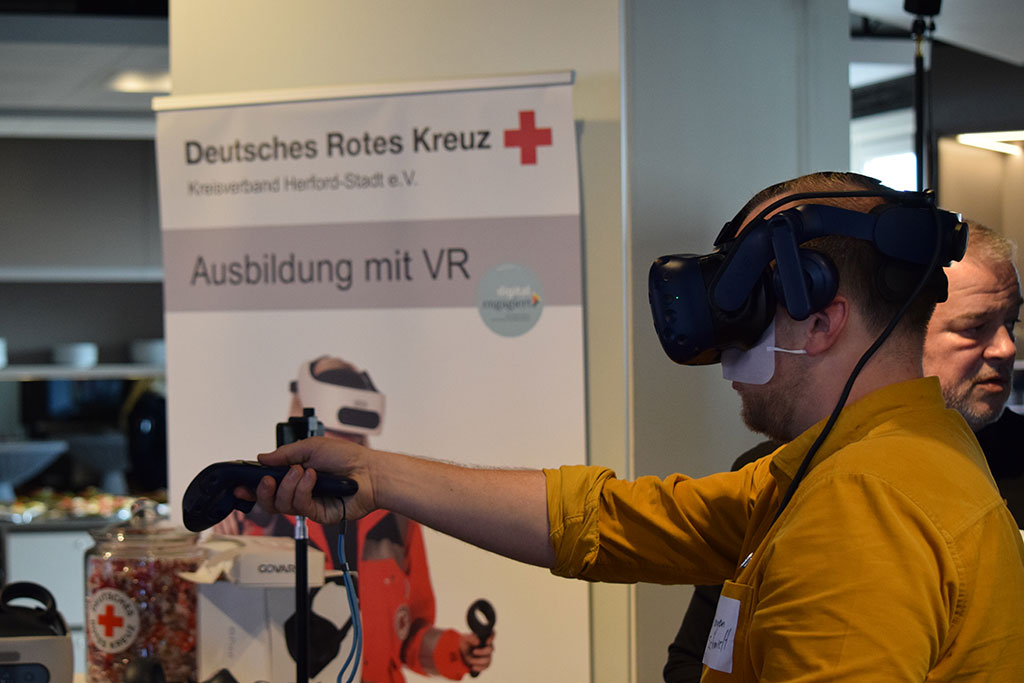 Teilnehmer mit VR-Brille und Fernbedienung