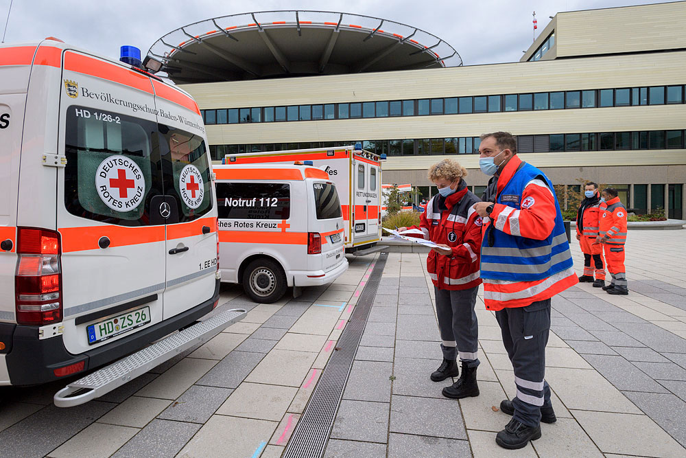 DRK-Mitarbeiter bei ihren Fahrzeugen