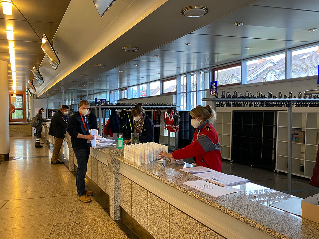 An der Theke bereiten sich DRK-Mitarbeiter auf den Empfang der Impfwilligen vor