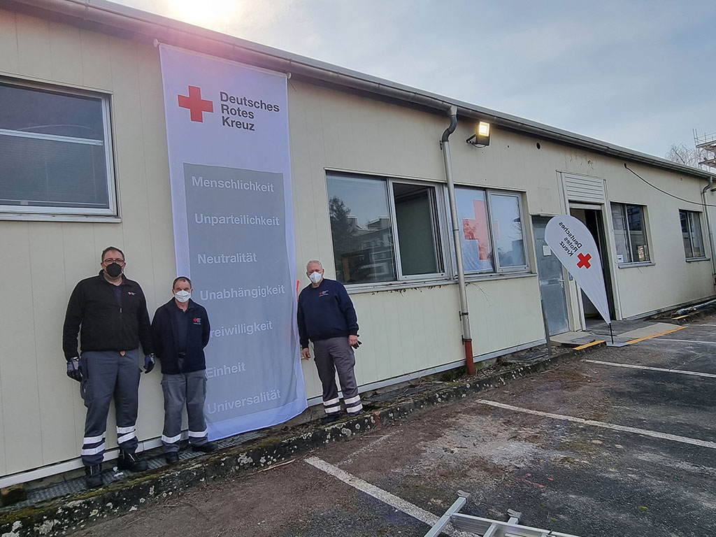 Drei Ehrenamtliche Helfer vor dem ehemaligen Warehouse.