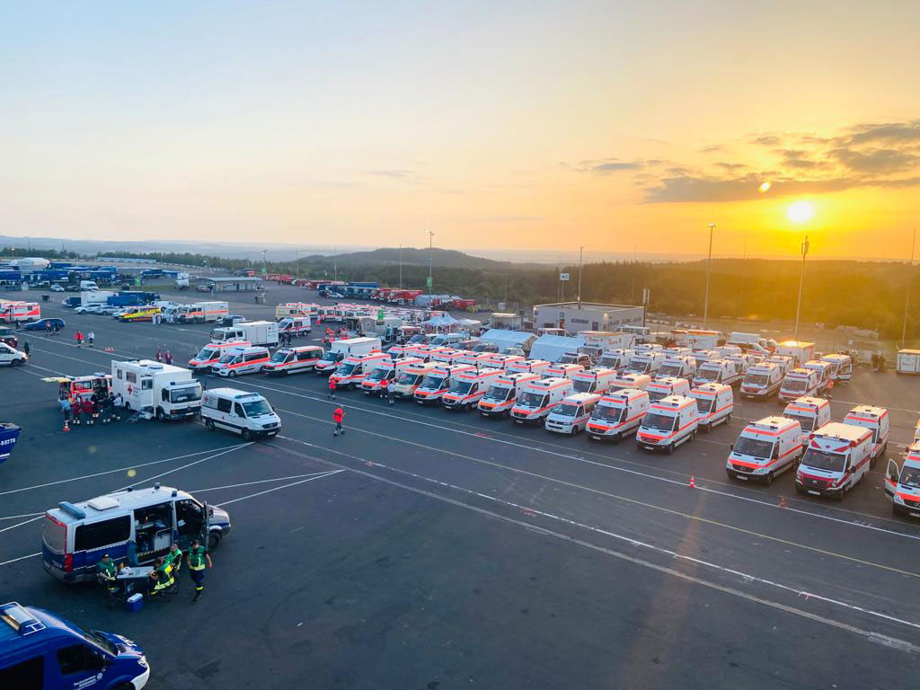 Viele geparkte DRK-Fahrzeuge auf einem großen Platz