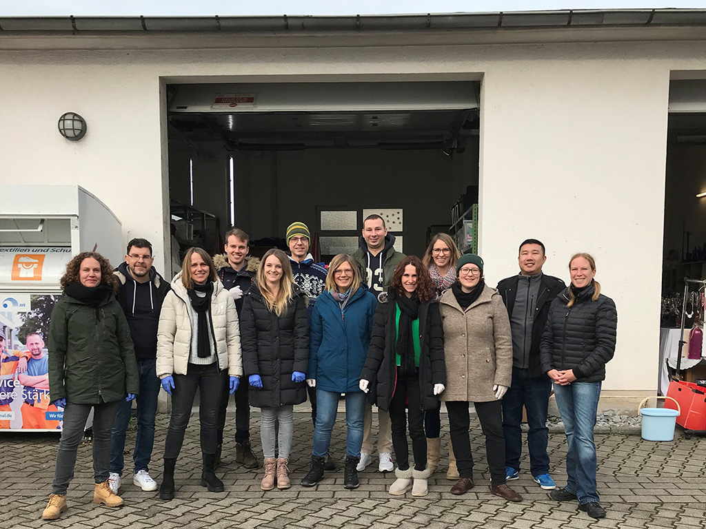 Gruppenbild der SAP-Mitarbeiter vor dem Kleiderladen