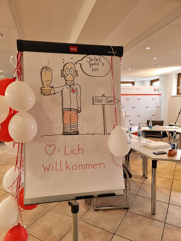 Schild mit der Aufschrift Jetzt geht's los und Herzlich Willkommen und Wegweiser Not-San