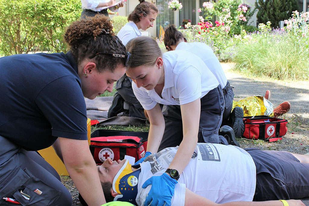 Zwei Sanitäterinnen versorgen eine verletzte Person am Unfallort