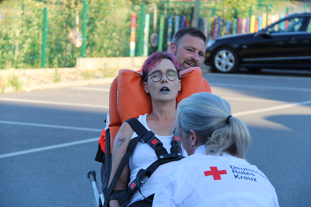 Zwei Sanitäter-innen transportieren ein Chlorgasopfer auf einer Trage