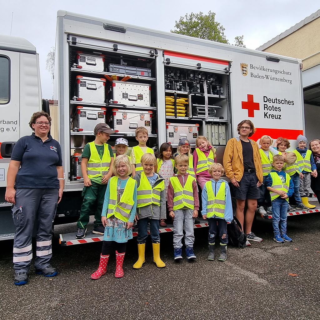 Gruppenbild mit Kindern und Betreuerinnen vor einem Rettungswagen