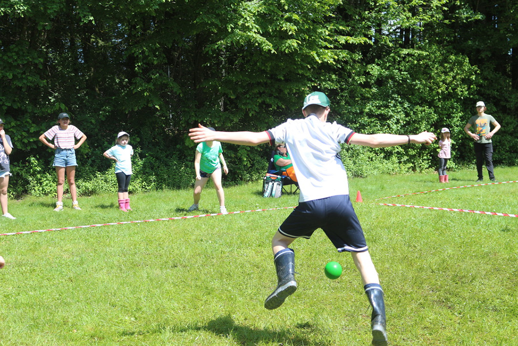 Kinder und Jugendliche beim Ballspiel auf einer Wiese