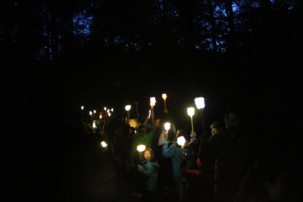 Kinder und Jugendliche beim nächtlichen Fackellauf im Wald
