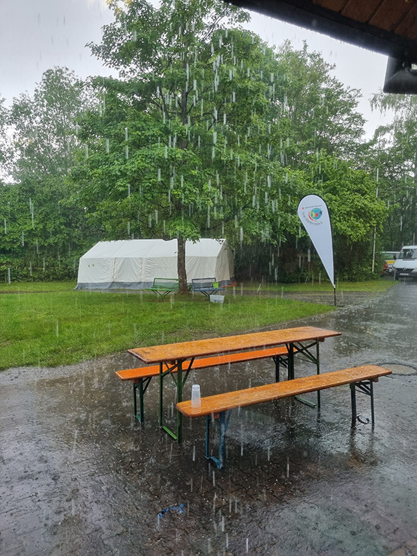 Bierbänke und JRK-Fahne in strömendem Regen