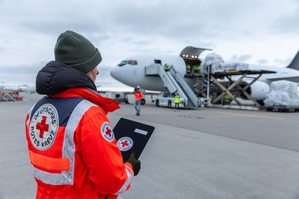 DRK-Mitarbeiter auf den Flugfeld bei einem Flugzeug, das mit Hilfsgütern beladen wird; Foto: Moritz Meyer