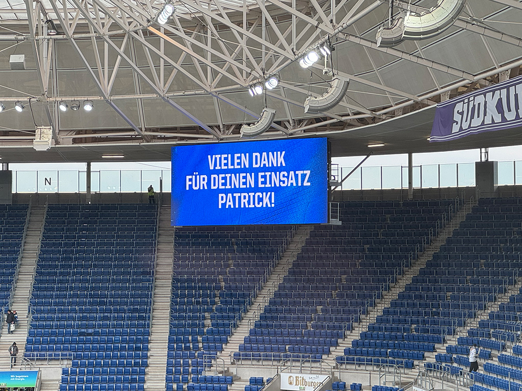 Anzeigenmonitor im Stadion mit blauem Hintergrund und dem Text  Vielen Dank für Deinen Einsatz Patrick!
