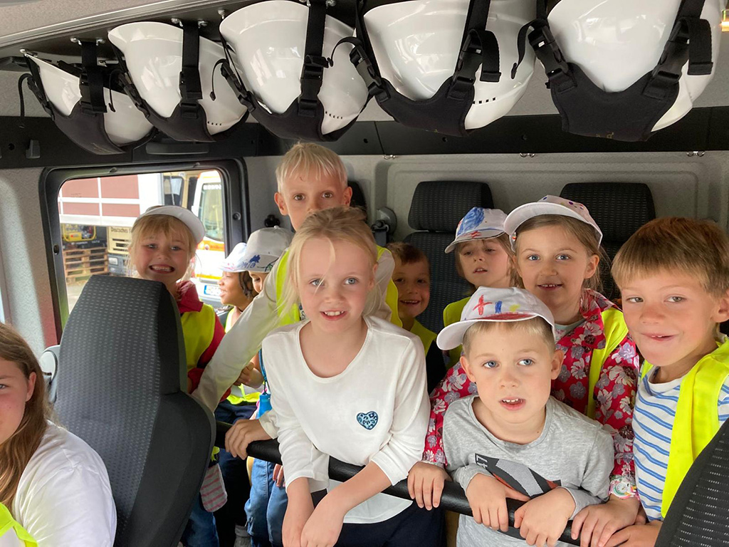 Gruppenbild der teilnehmenden Erstklässler im Innenraum eines Rettungsfahrzeugs.