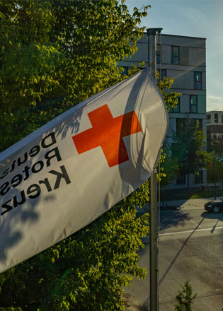 DRK-Fahne vor einem Baum