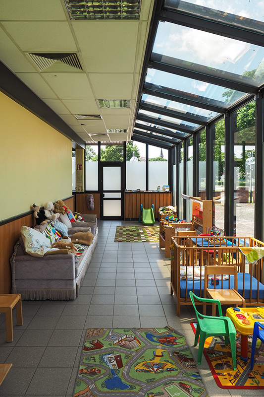 Wintergarten mit Sofa und Kinderbetten im Mutter-Kind-Haus