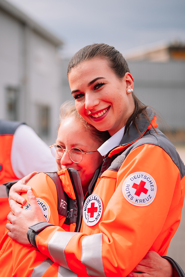 Sanitäterin umarmt eine andere Sanitäterin