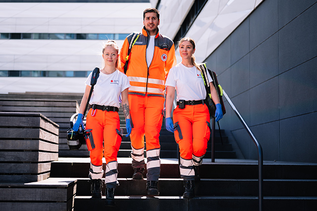 Drei Notfallretter-innen laufen eine Treppe hinunter