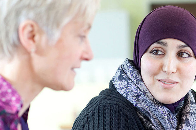 Frau mit Kopftuch spicht mit einer anderen Frau